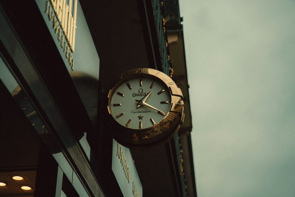 An ornate clock hangs on a building's exterior.