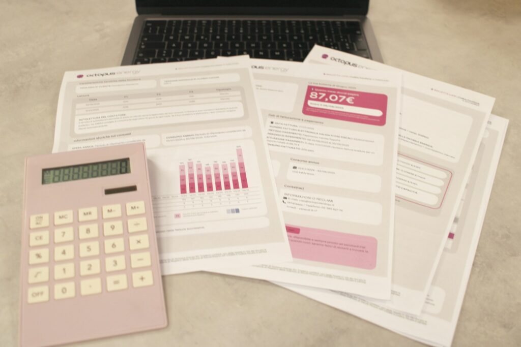 Bills, calculator, and a laptop: financial tasks underway.